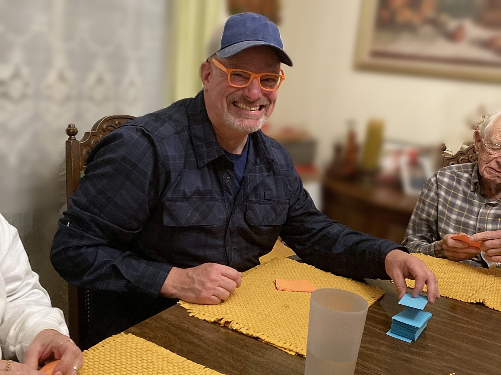 A man in orange Expert Eyewear laughing at the table