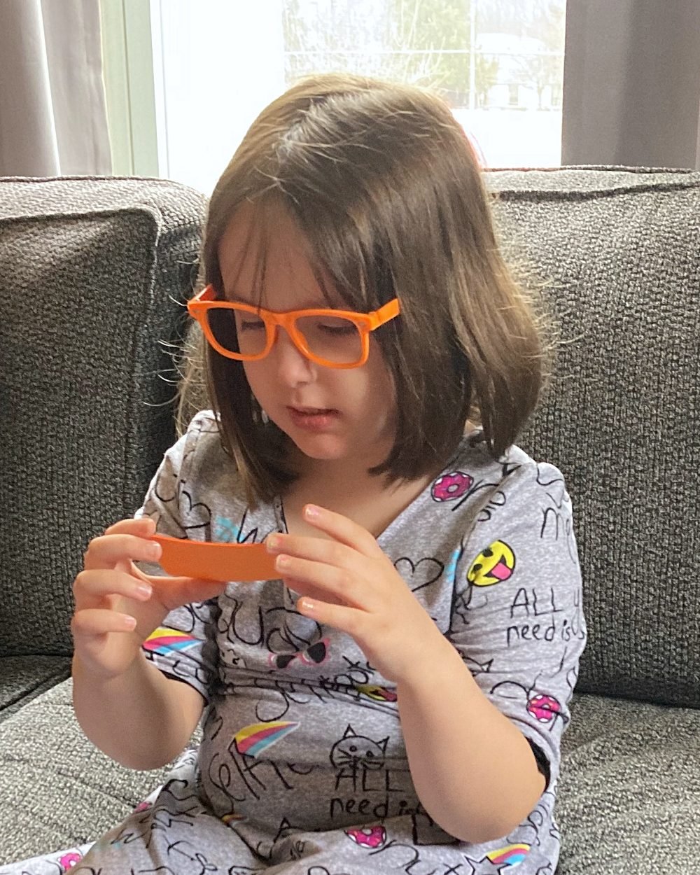 A girl on a couch reading an orange card